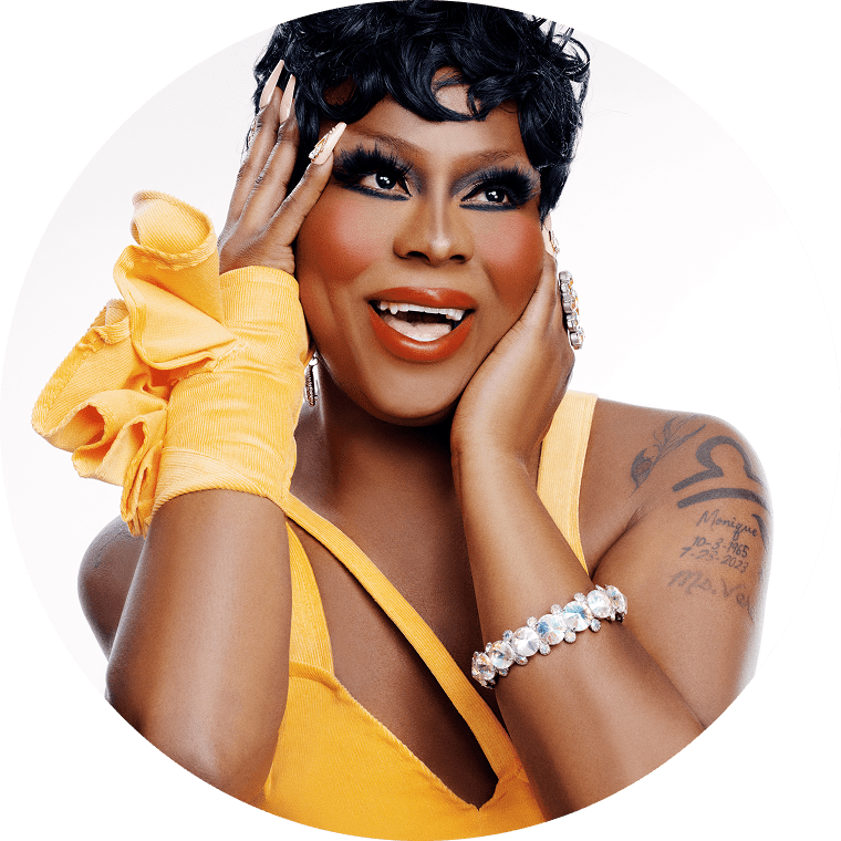 sasha the drag queen smiles and looks off to the side of the camera with an orange outfit