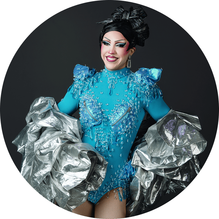 virginia, a drag queen in nashville, smiles with her hair up while wearing a fabulous blue outfit
