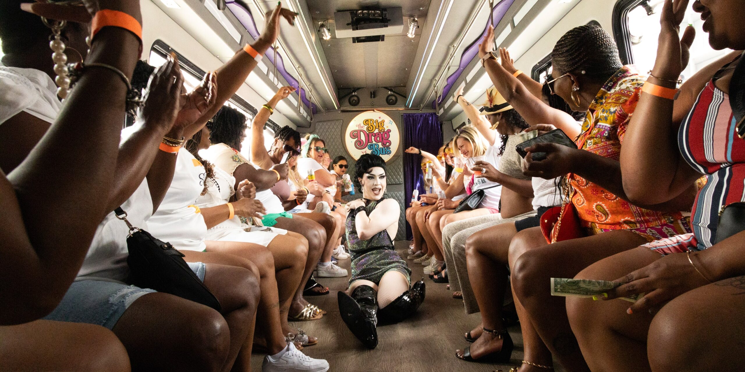 a drag queen slides down the runway while people cheer