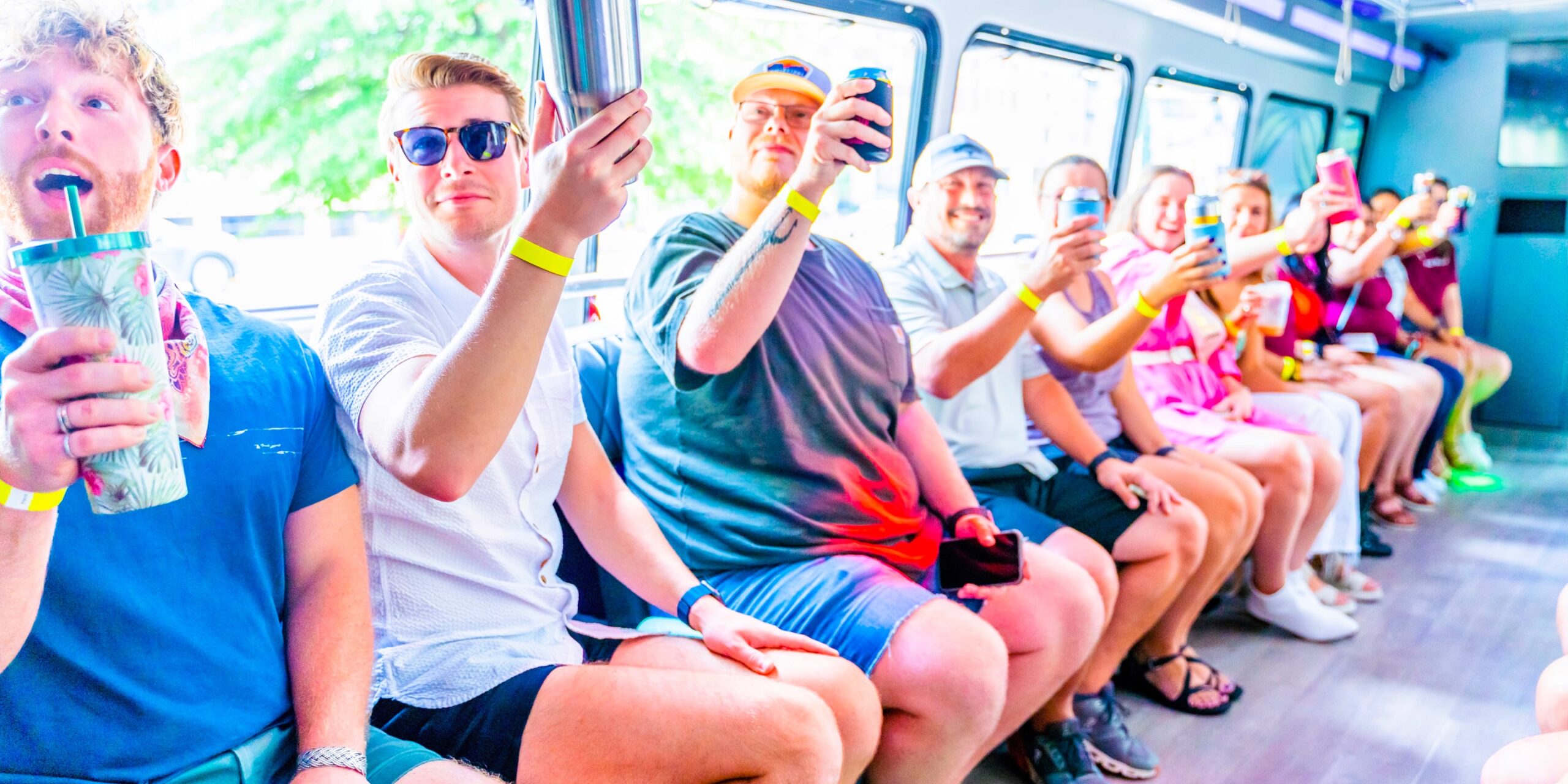 a group of people raise their drinks to cheers while on a nashville party bus private tour